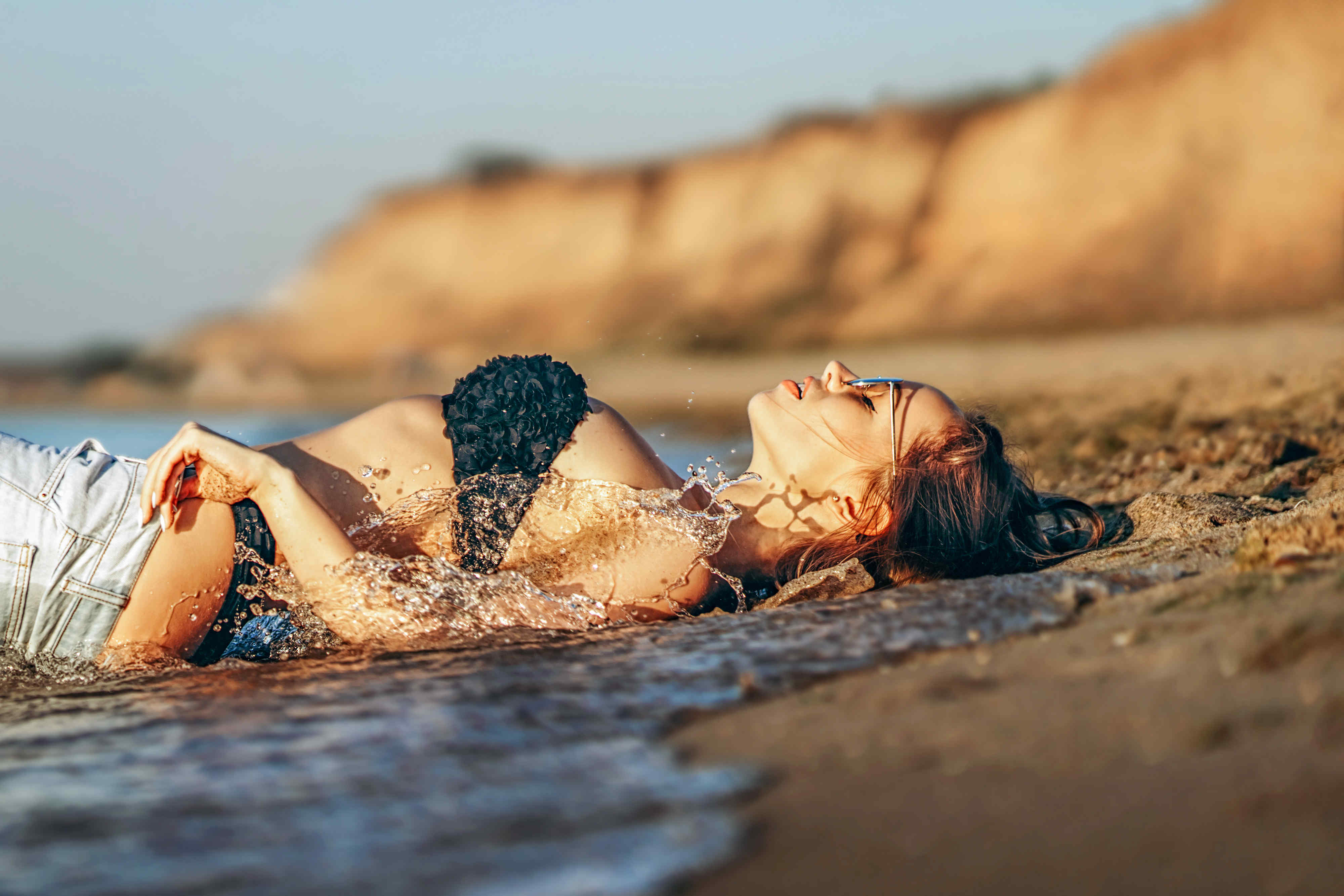黑发美女在海边的海滩上休息摄影图